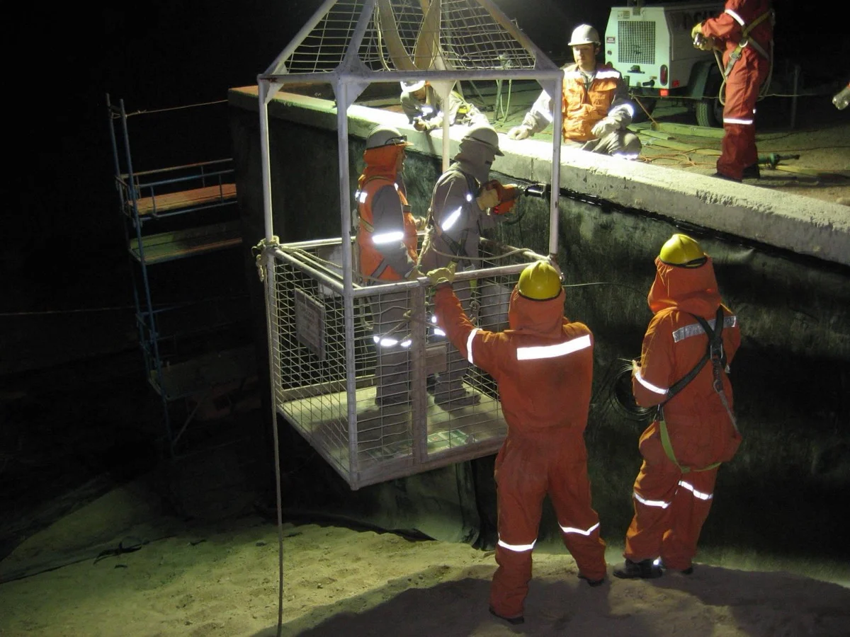 Equipo trabajando de noche en la impermeabilización de un pozo en Minera Lomas Bayas.
